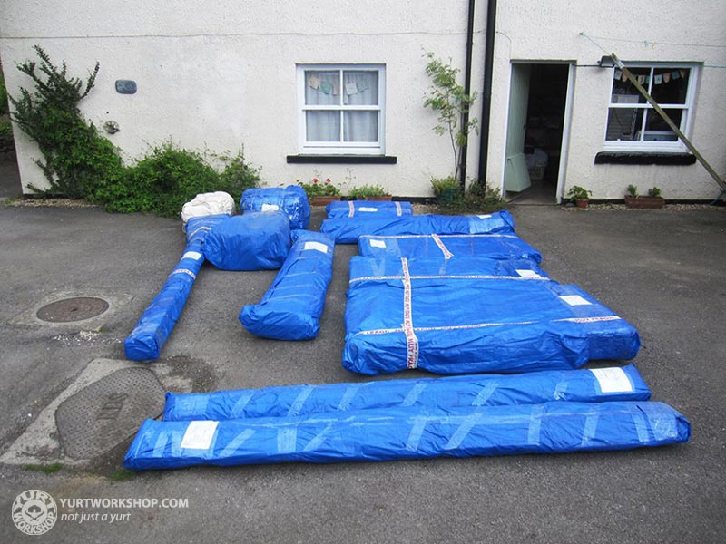 A 16 foot Yurt Workshop yurt after delivery, with its components wrapped and laid out at the destination
