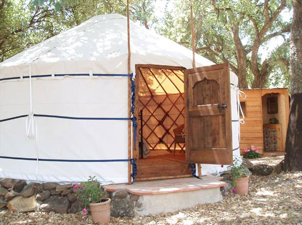 Cream canvas Yurt Workshop yurt with open wooden door and visible chestnut lattice