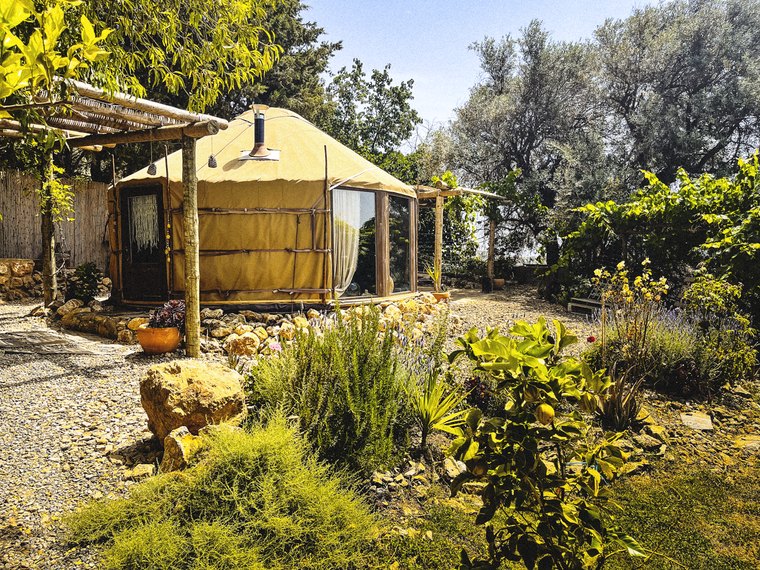 Insulated Glass Wall yurt with wood-burning stove set in a Mediterranean garden