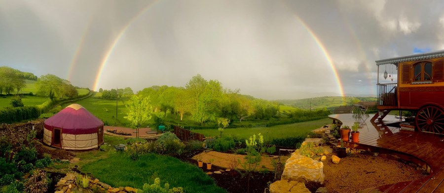 Yurt Workshop yurt beneath a double rainbow in a green rural landscape