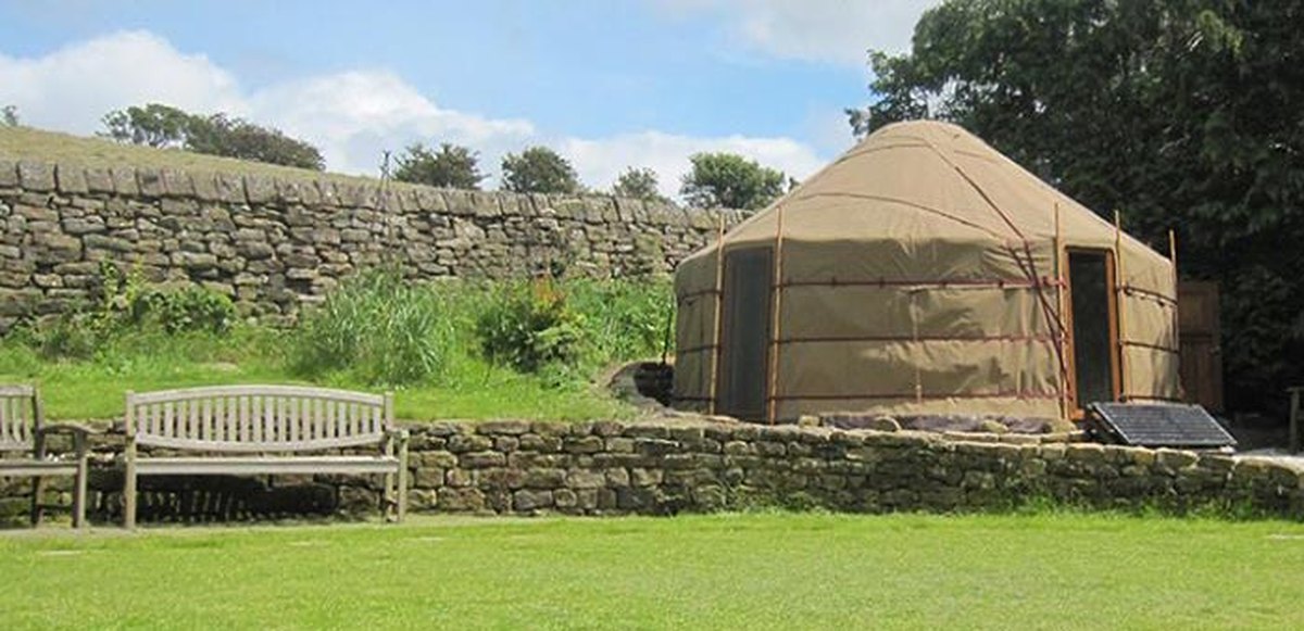Insulated Yurt Workshop yurt in a stone-walled garden