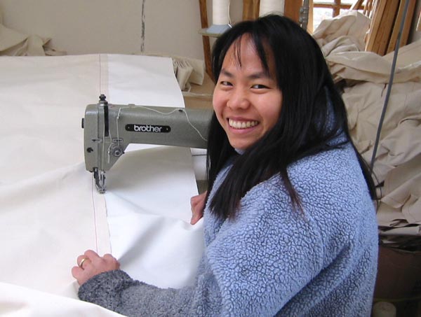 Ratna Matthews sewing canvas covers for a Yurt Workshop yurt